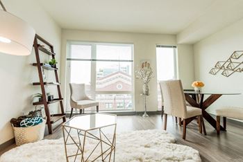 a living room with a table and chairs and a large window at Icon Apartments, Washington, 98104